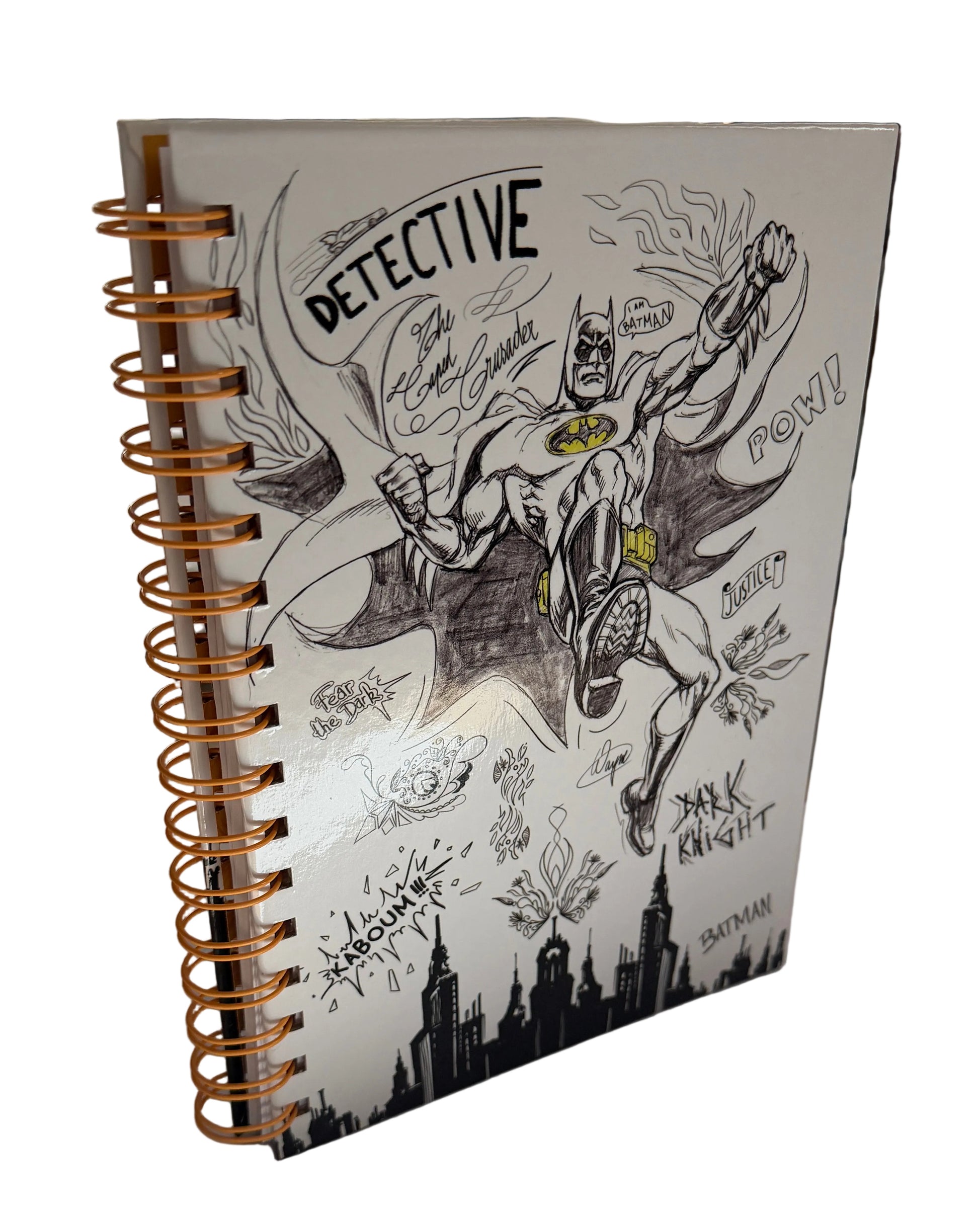 Notebook with a Batman illustration on the cover, placed on a surface.