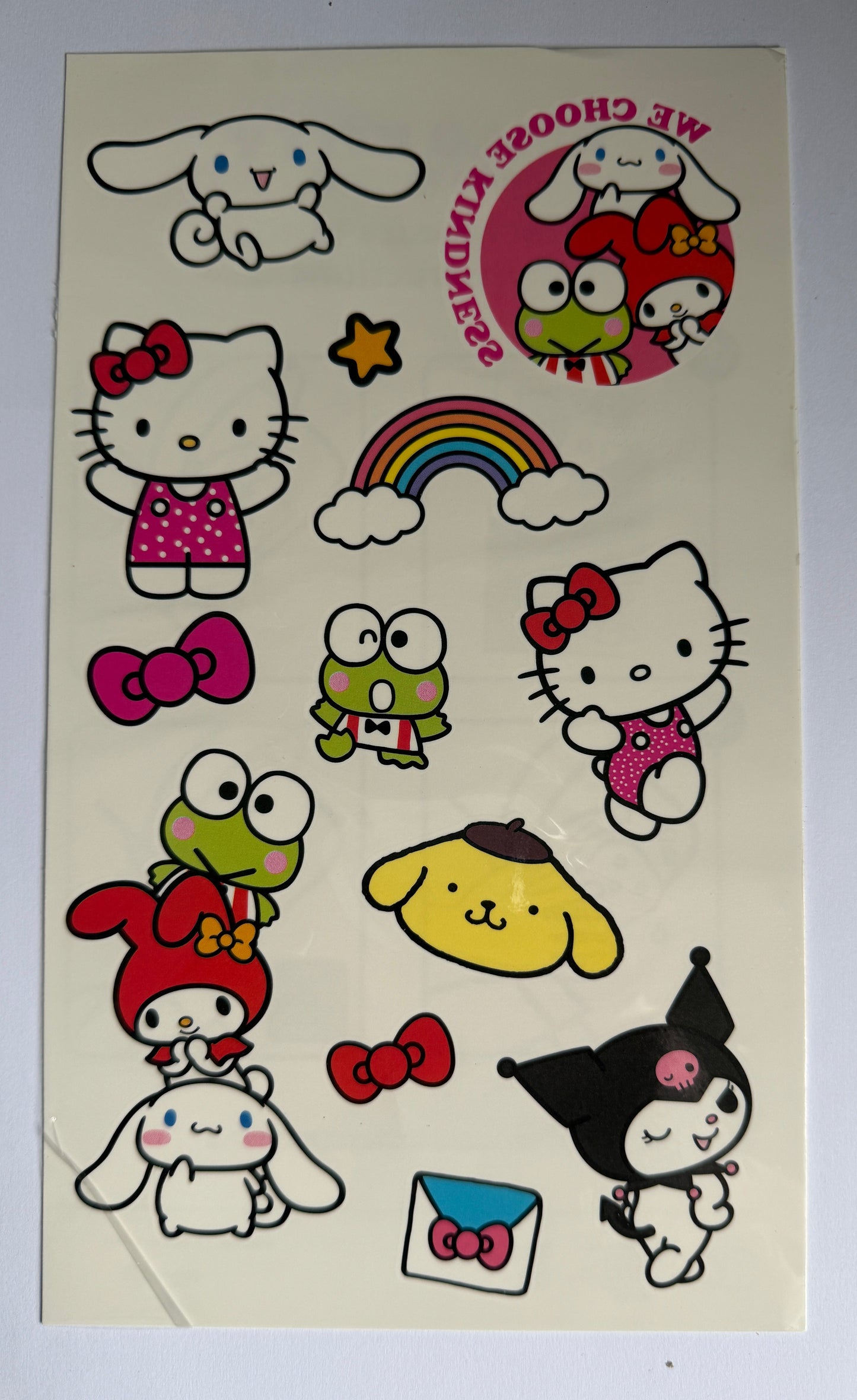 Sheet of Hello Kitty and friends stickers on a beige backing with a gray background