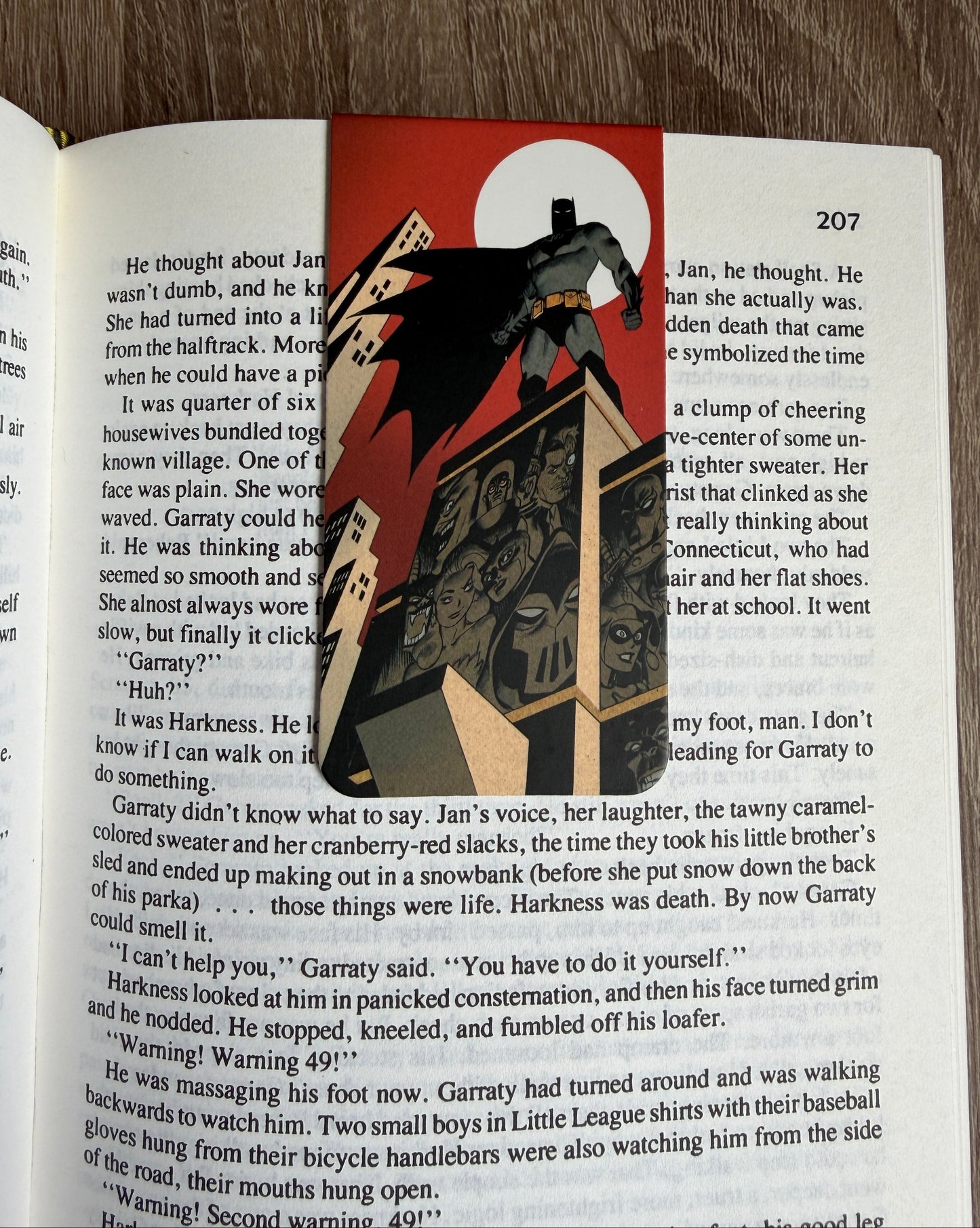 Decorative bookmark with a design of a character and cards on an open book.