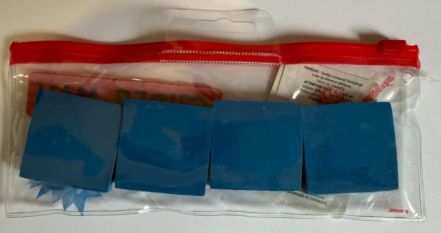 A clear zippered pouch containing four blue rectangular blocks and a small white paper insert, photographed on a plain white background.