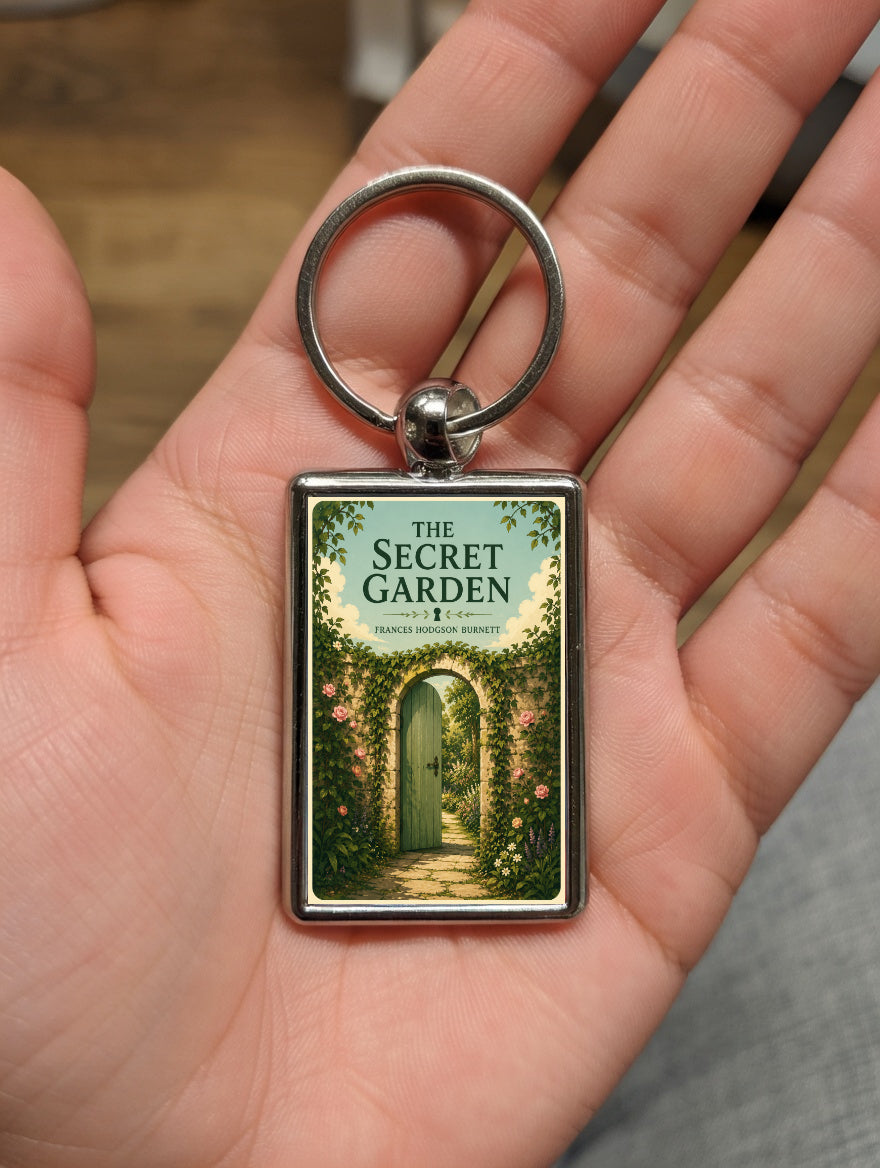 The Secret Garden Gate design metal keyring shown in a hand