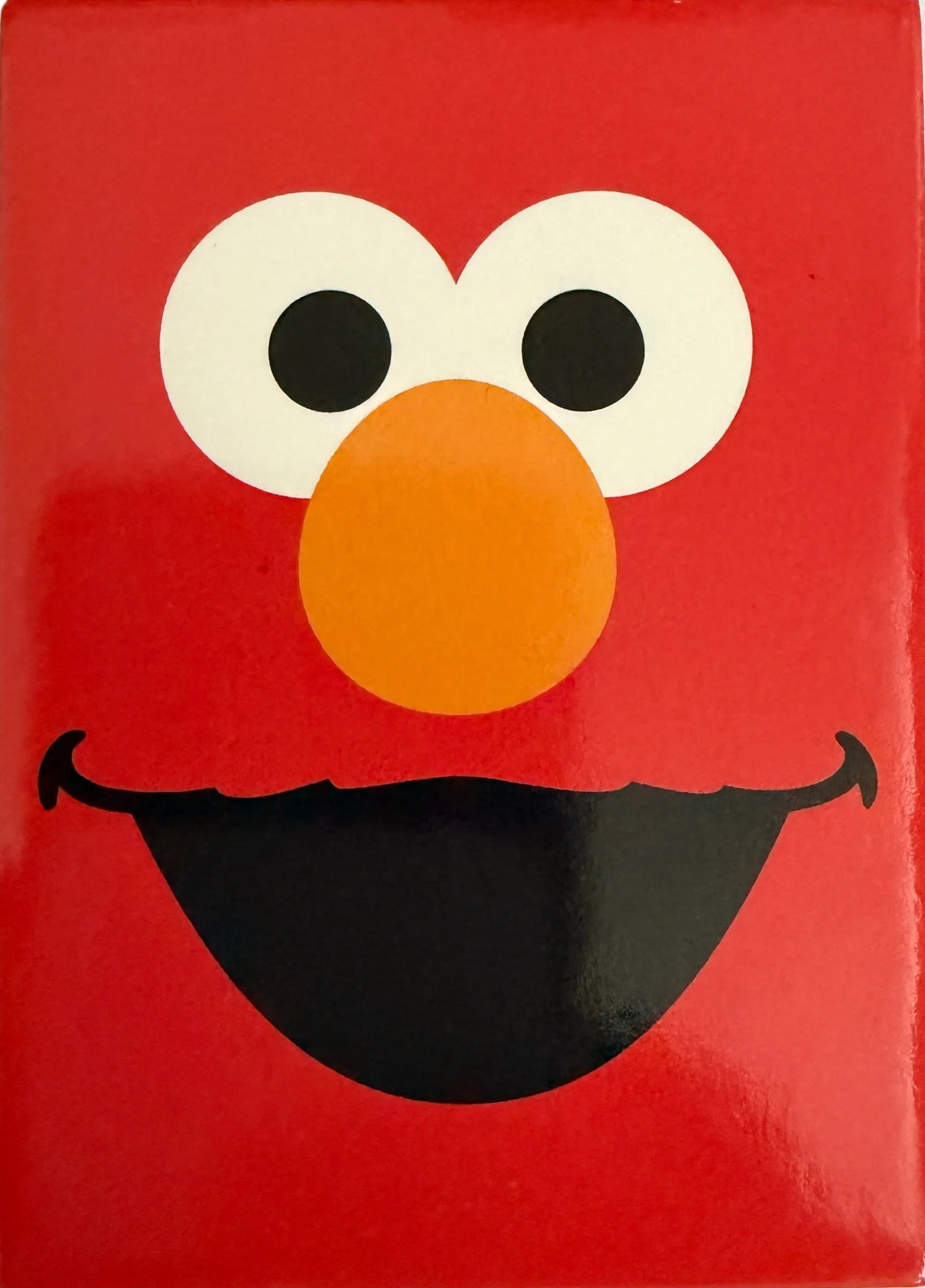 Red rectangular Elmo fridge magnet on a white background close up