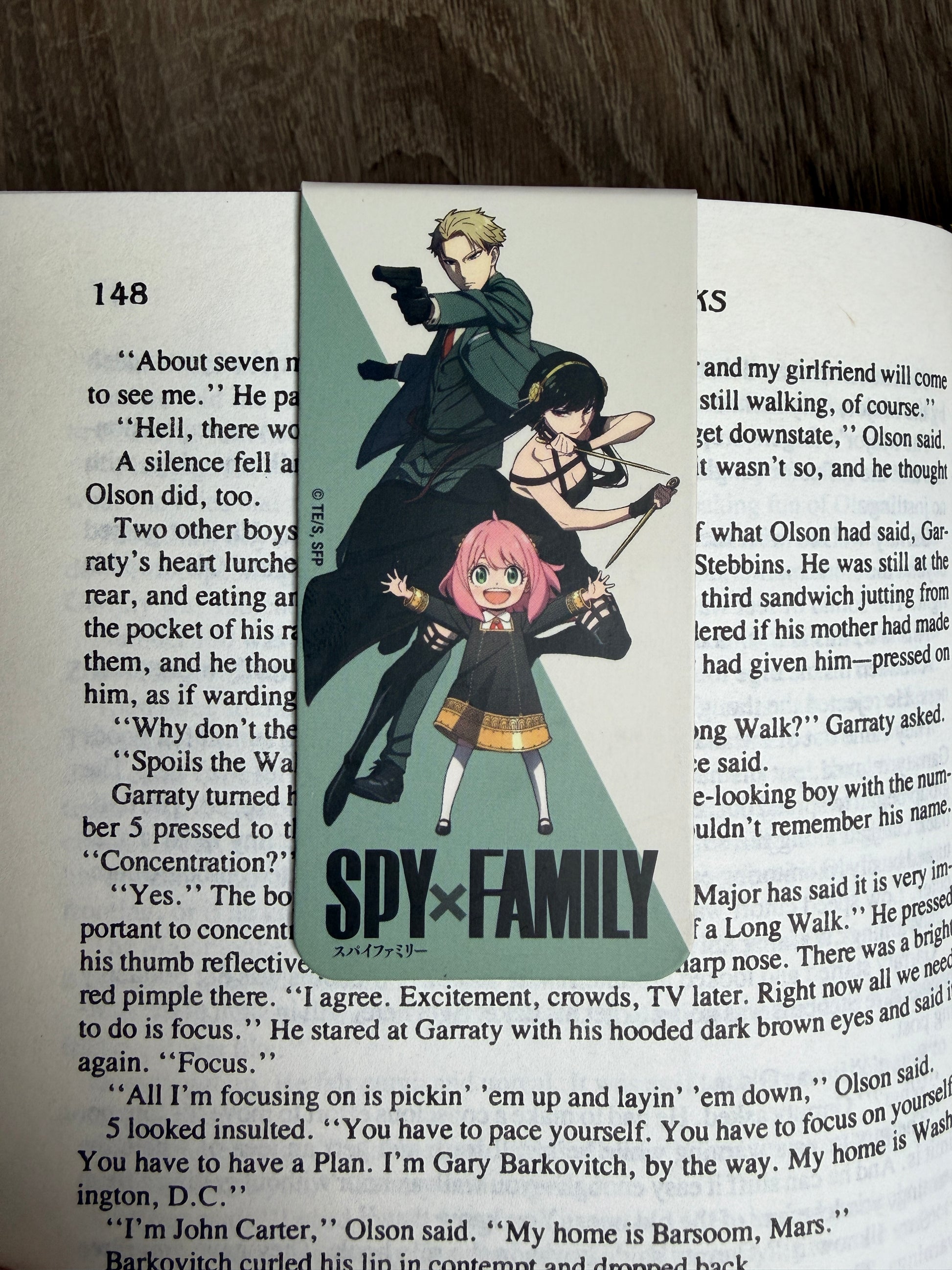 Anime-style illustration of three characters on a book page