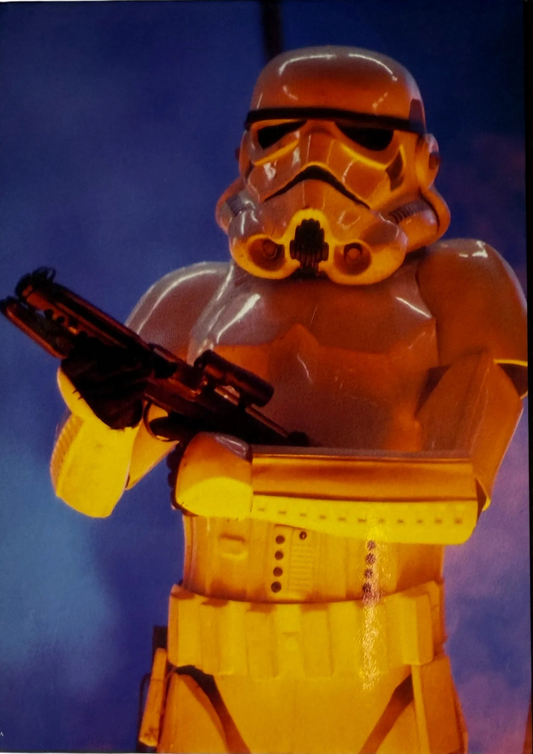 Yellow stormtrooper figure from Star Wars holding a weapon against a blue background